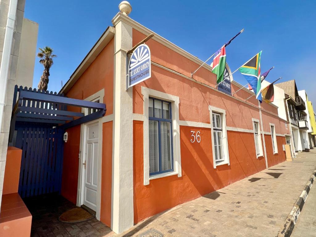 un edificio con banderas a un lado. en The Secret Garden Guesthouse en Swakopmund