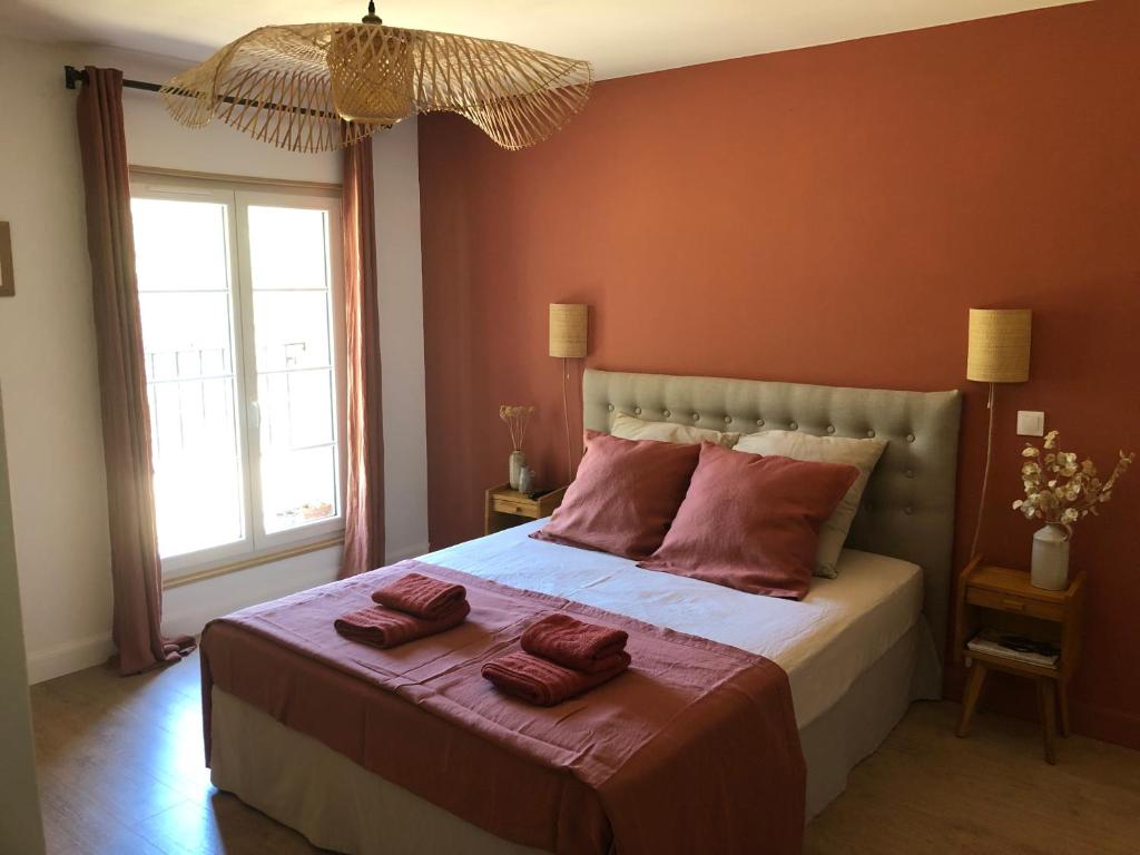 um quarto com uma cama grande e paredes vermelhas em Le Mas Justin em Gordes