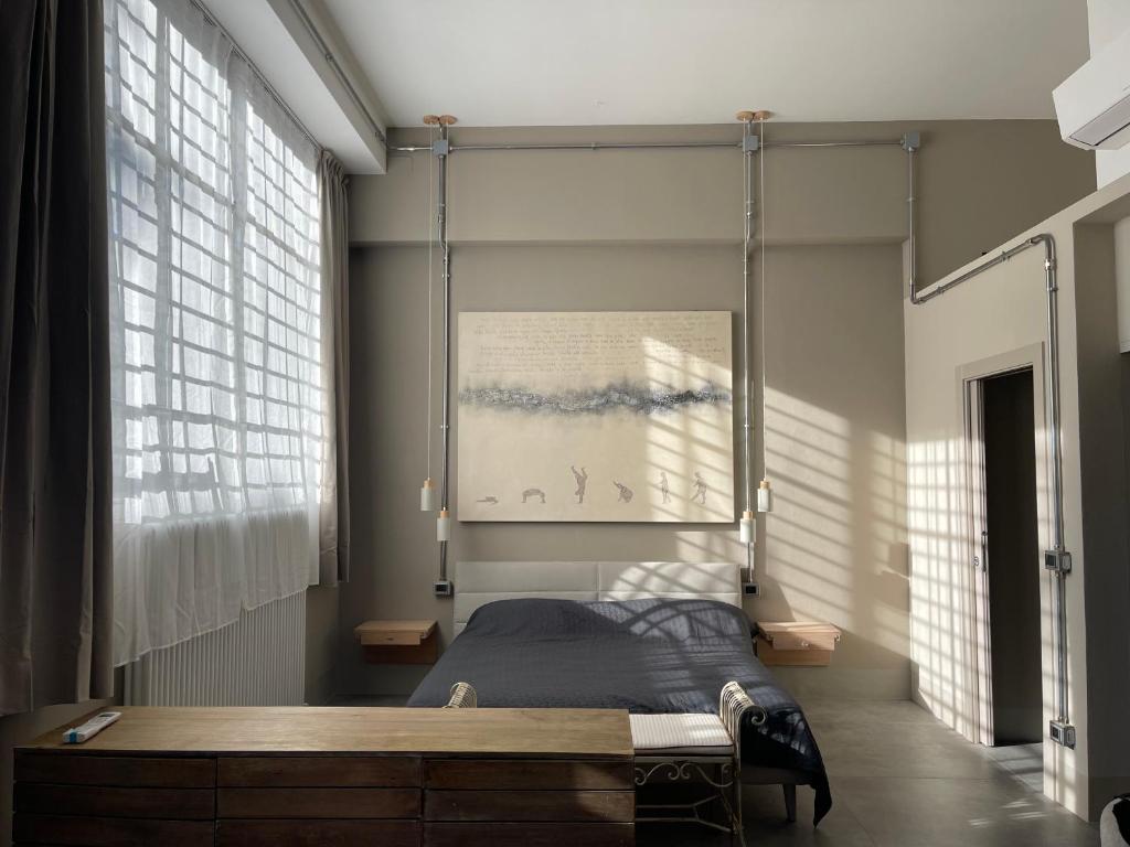 sypialnia z łóżkiem i obrazem na ścianie w obiekcie TRETRE w Bolonii