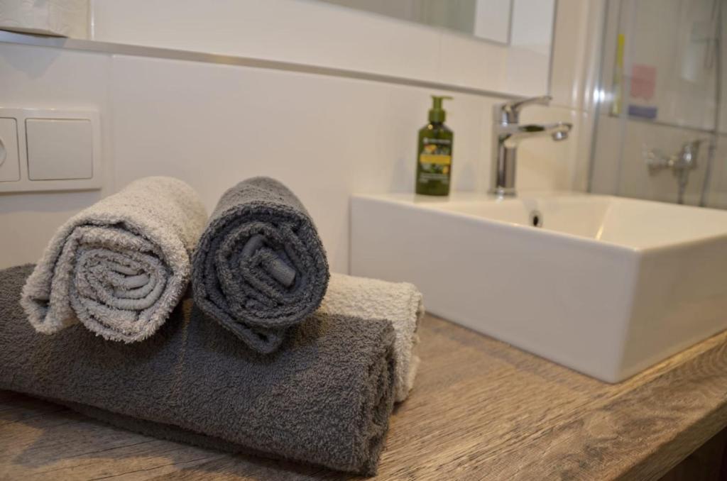 ein Badezimmer mit Handtüchern auf einer Theke neben einem Waschbecken in der Unterkunft Sky Thermal Apartment in Karlsbad