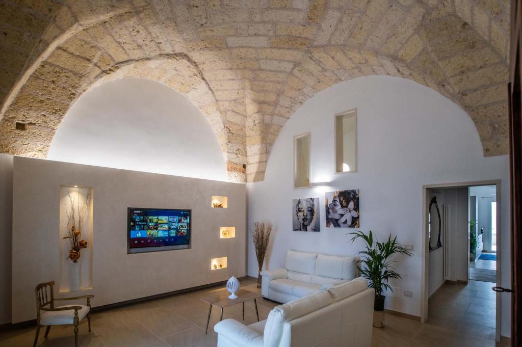 sala de estar con sofá blanco y techo de piedra en La Volta - Casa Vacanze, en Galatina