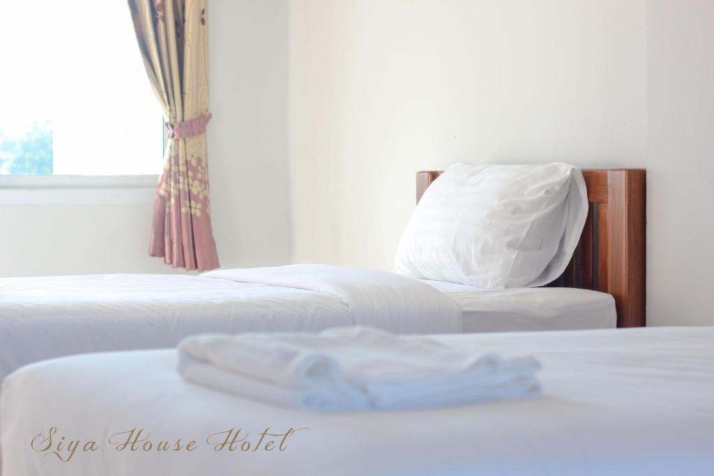 Postel nebo postele na pokoji v ubytování Siya House Hotel