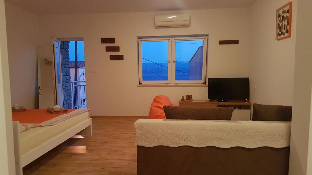 Televízia a/alebo spoločenská miestnosť v ubytovaní Apartmani LuMa Apartman Marija
