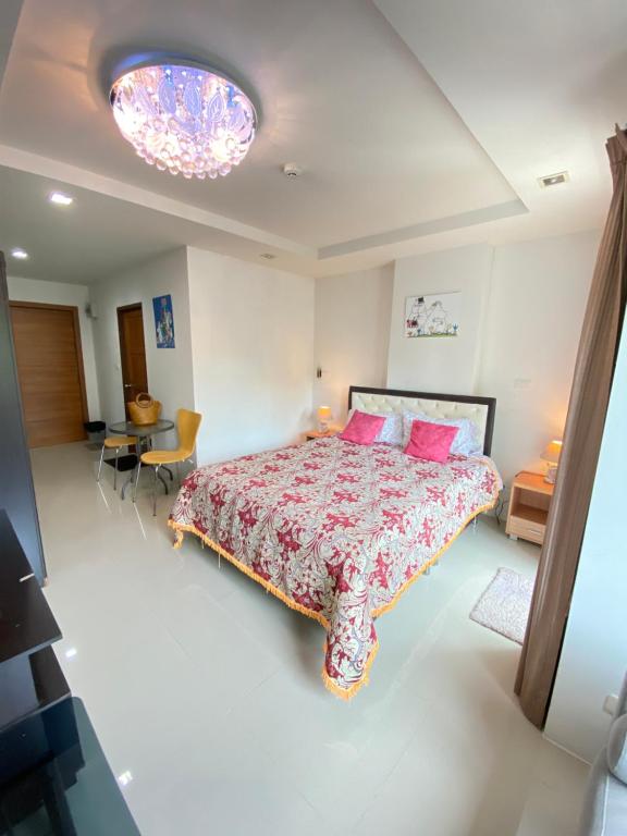 um quarto com uma cama grande e almofadas cor-de-rosa em Beach 7 Condo, Pattaya em Praia de Jomtien