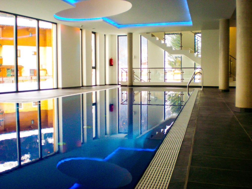 a swimming pool with blue chairs in a building at Modern Mountain Apart 2 - directly by Skiing area in Rauris