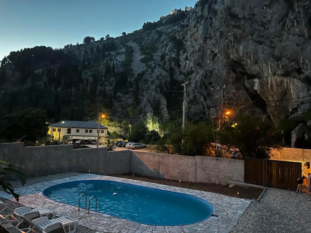 a swimming pool in front of a mountain at Vila Nomada in Blagaj