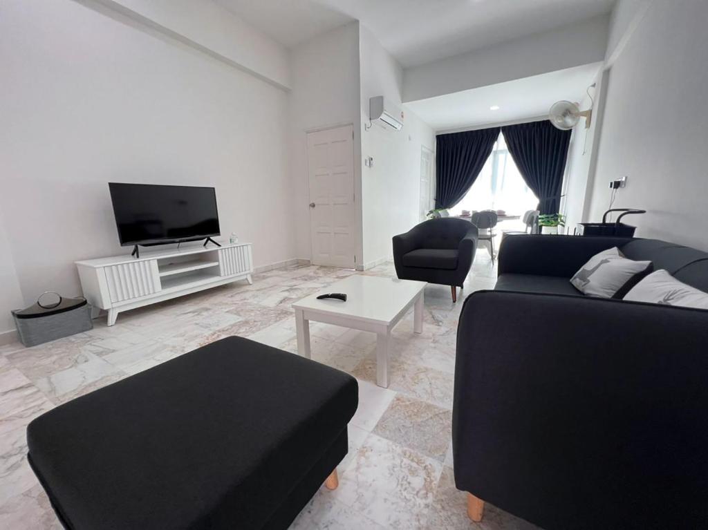 a living room with a couch and a tv at Luï Luï Comfy Condo in Great Location in Kuah