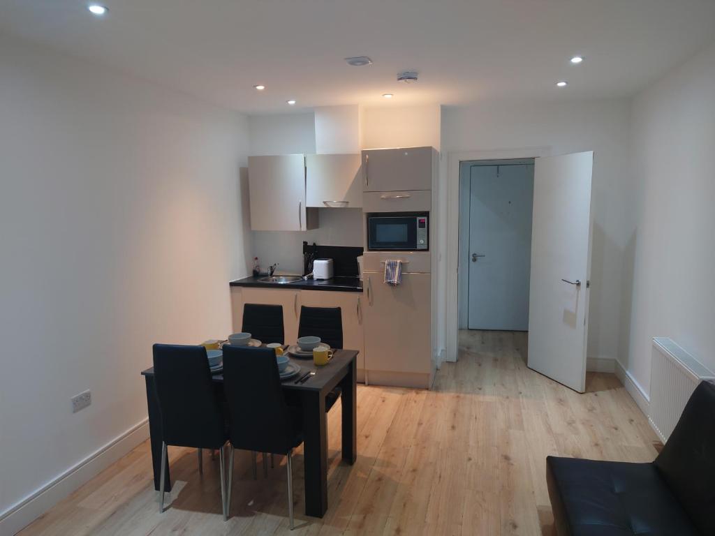 a kitchen and dining room with a table and chairs at City Sparrow Apartments 6 in London