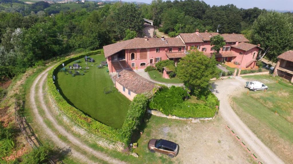 uma vista aérea de uma casa grande com um carro estacionado no quintal em La vecchia Cascina Rossa em Fubine