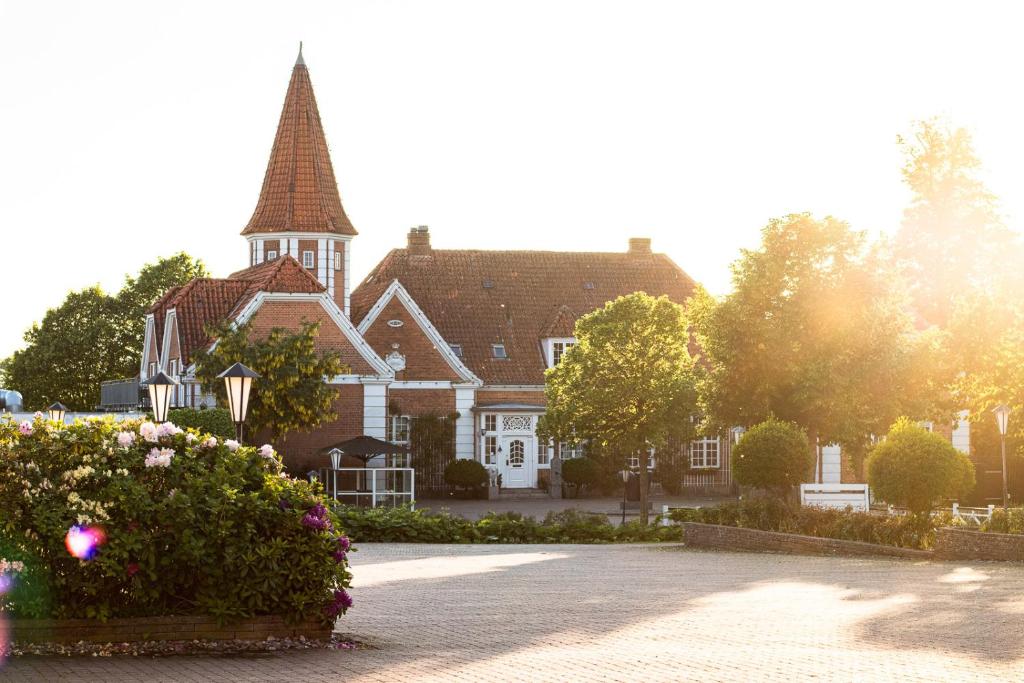 een groot huis met een toren erop bij Hotel Sørup Herregaard in Ringsted