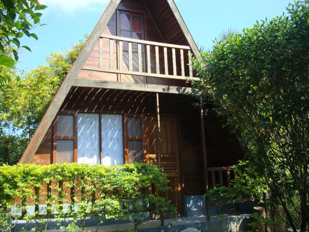 ein kleines Haus mit Balkon darüber in der Unterkunft Chalès em Ilhabela Litoral Norte in Ilhabela