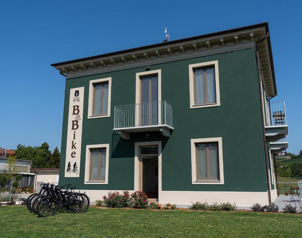 zielony budynek z rowerami zaparkowanymi przed nim w obiekcie B & Bike di Ristorante Italia w mieście Mombello Monferrato
