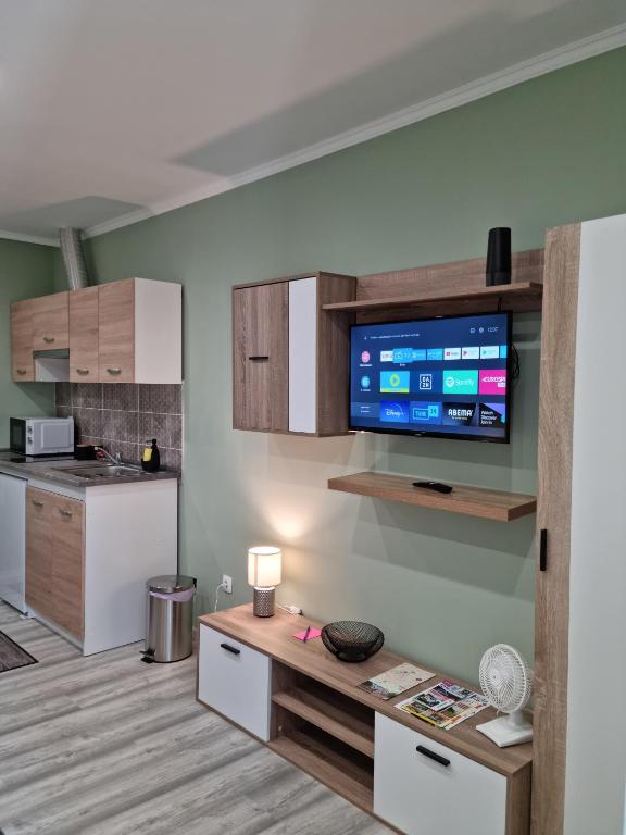 a living room with a tv on a wall at Belvárosi Pihenőház in Békéscsaba