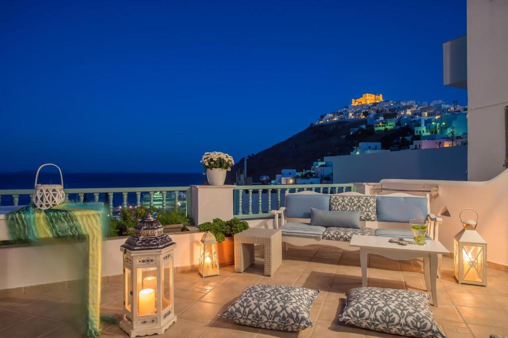 a rooftop patio with a view of the city at night at Aphrodite Studios in Astypalaia