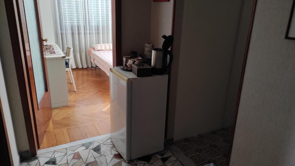Un pasillo con una habitación con nevera y un gato. en Casabella Silvana en Aosta
