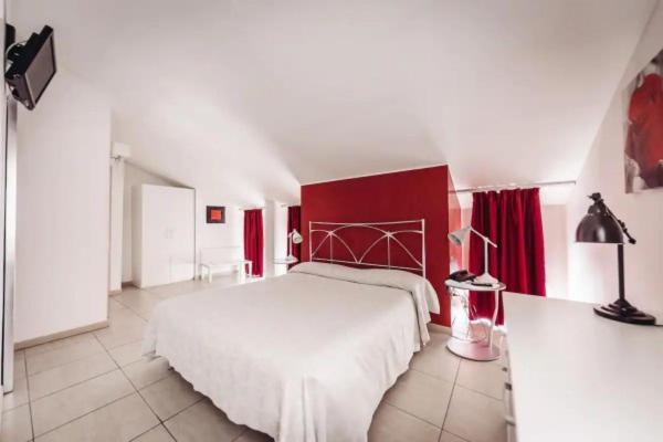 una camera con letto bianco e pareti rosse di Cà Dei Barcaroli a Mestre
