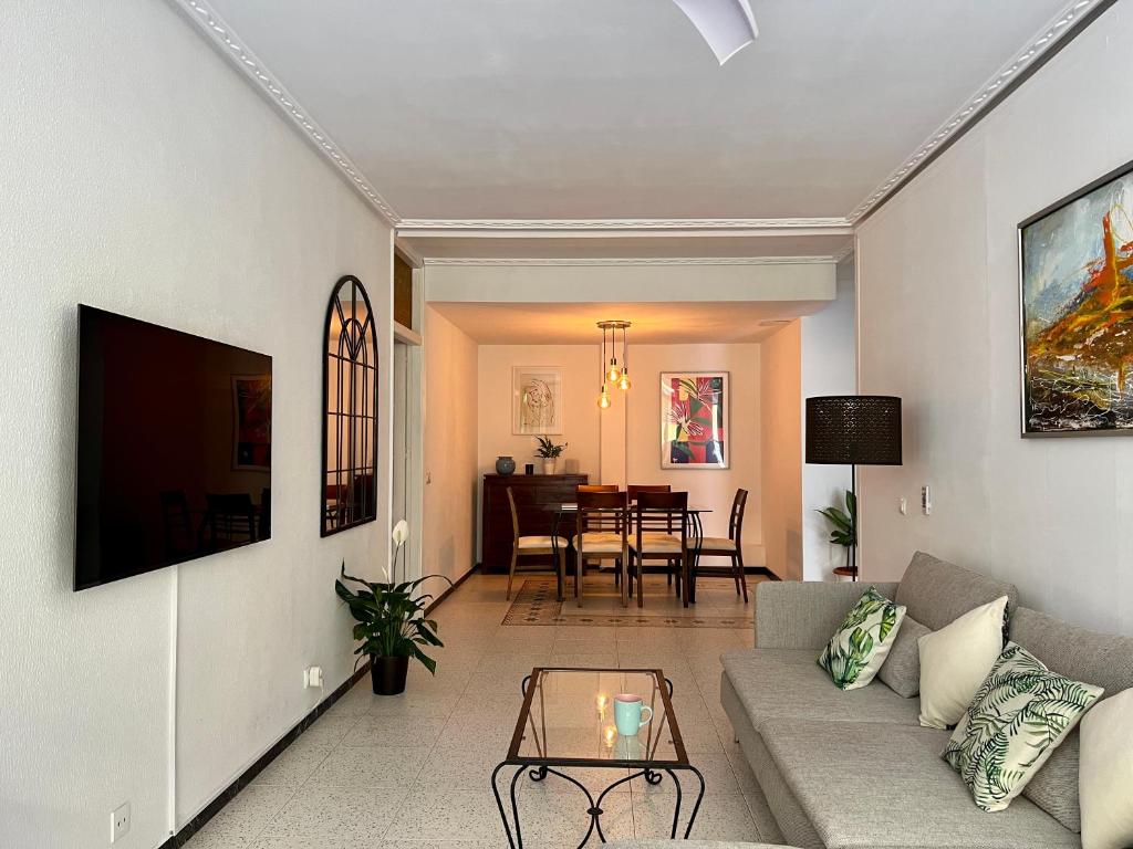 ein Wohnzimmer mit einem Sofa und einem Tisch in der Unterkunft Spacious 4 Bedrooms apartment for family or several friends in San Bartolomé de Tirajana
