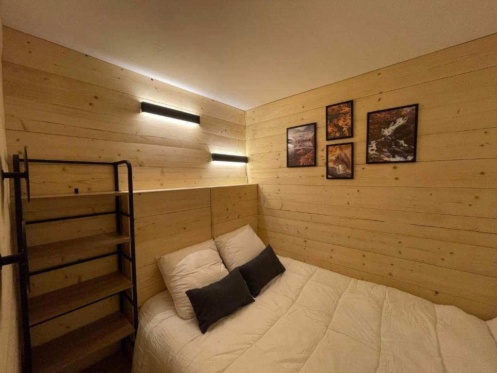 een kamer met een bed in een houten kamer bij LeChalet N22 Au pied des pistes in Saint-Lary-Soulan