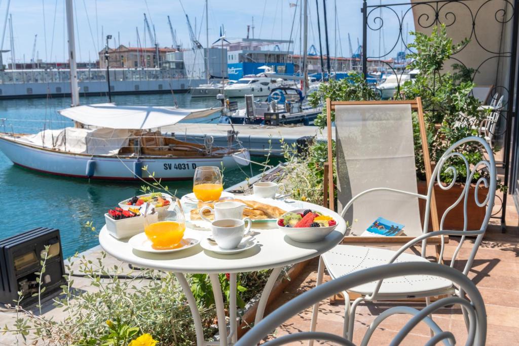 a table with breakfast food on a balcony with a marina at Locanda da Toto in Genova