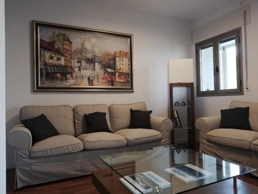 a living room with a couch and a painting on the wall at Gran piso en zona comercial Malaga in Málaga