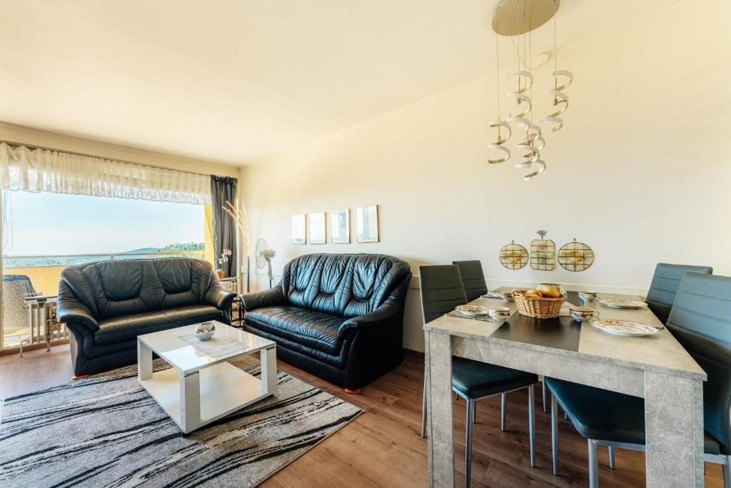 霍蓋思的住宿－Ferienwohnung Harz-Flair 264，客厅配有皮革家具和桌子
