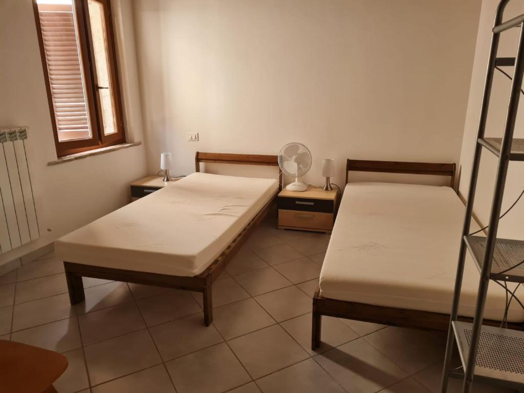 Habitación con 2 camas y ventilador. en Casa Ornella, en Nocera Umbra