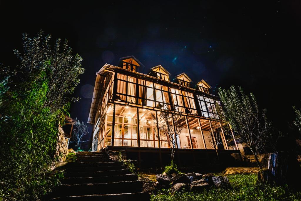 a large house is lit up at night at The Villster Resort in Kasol