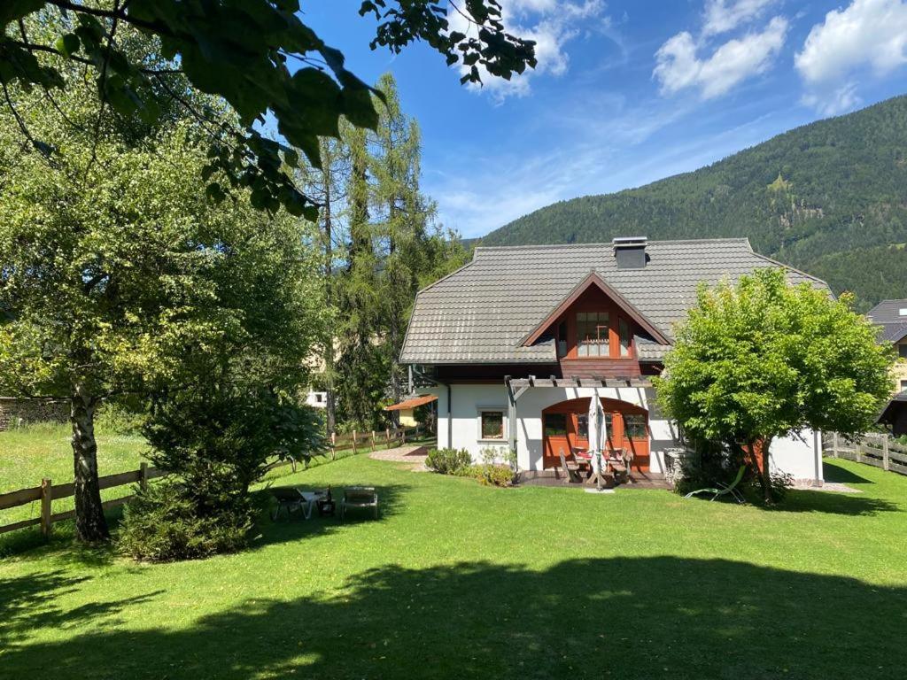 a house with a fence and a green yard at Villa Dona in Kranjska Gora