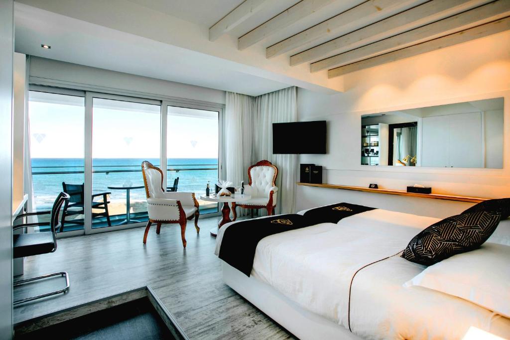 a bedroom with a bed and a view of the ocean at The Ciao Stelio Deluxe Hotel (Adults Only) in Larnaca