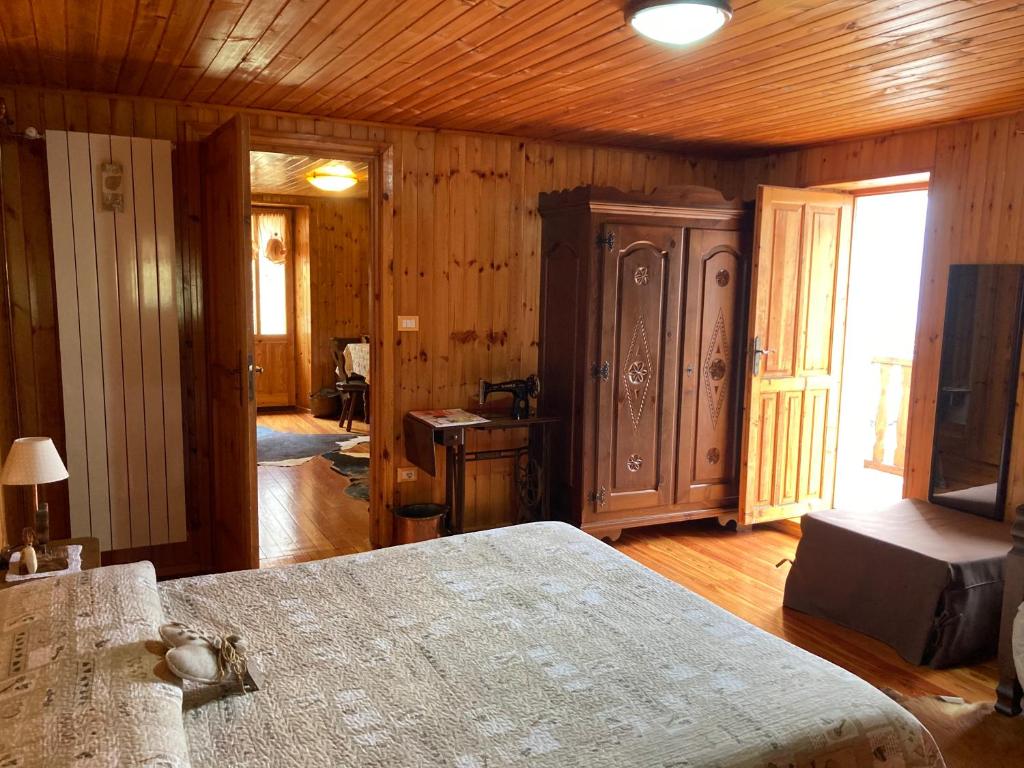 a bedroom with a bed and a wooden wall at B&B Maison Vallomy in Lillianes