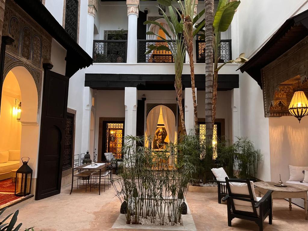 a courtyard with tables and chairs and a palm tree at RIAD ENNAFOURA BOUTIQUE HOTEL in Marrakesh