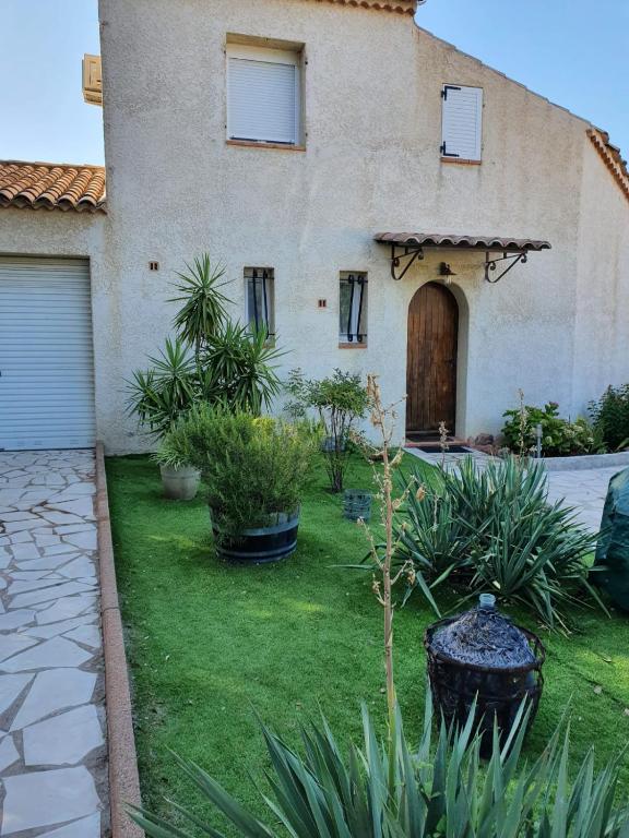une maison avec une cour ornée de plantes et une allée. dans l'établissement casa SamaSama, à Porto-Vecchio