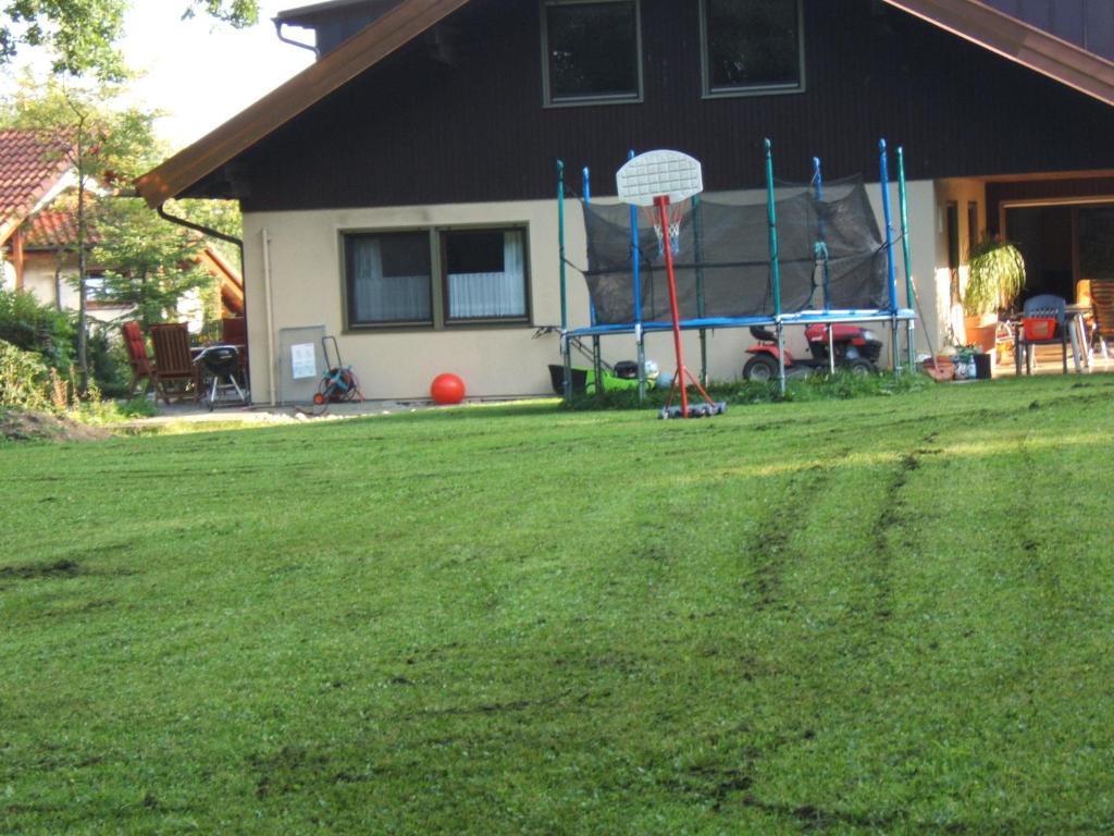 un patio con un aro de baloncesto delante de una casa en Ferienwohnung Schwahn, en Kleinschönach