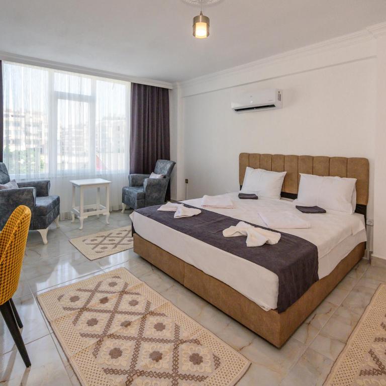 a bedroom with a large bed and a living room at Bo homes suıt apart in Demre