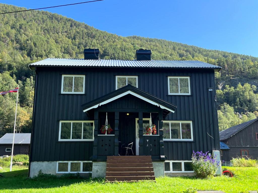 a black house with a mountain in the background at Nørdre-Repp in Boverdalen