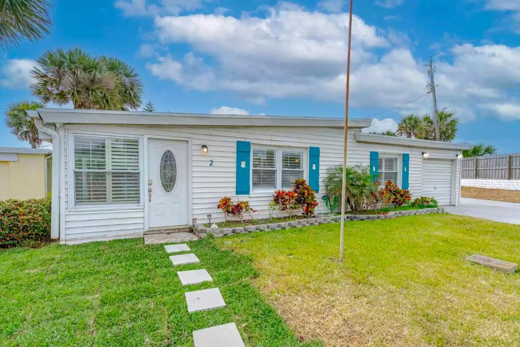 a small white house with blue accents at Bathing Suit Beach Bungalow in Ormond Beach