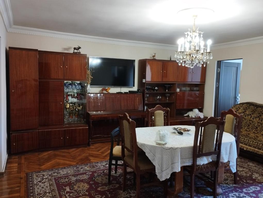 a dining room with a table and a tv at Tsovella House in Jermuk