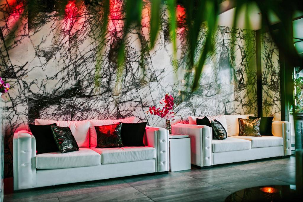 two white couches in front of a wall at The Ciao Stelio Deluxe Boutique Hotel - Adults Only in Larnaka
