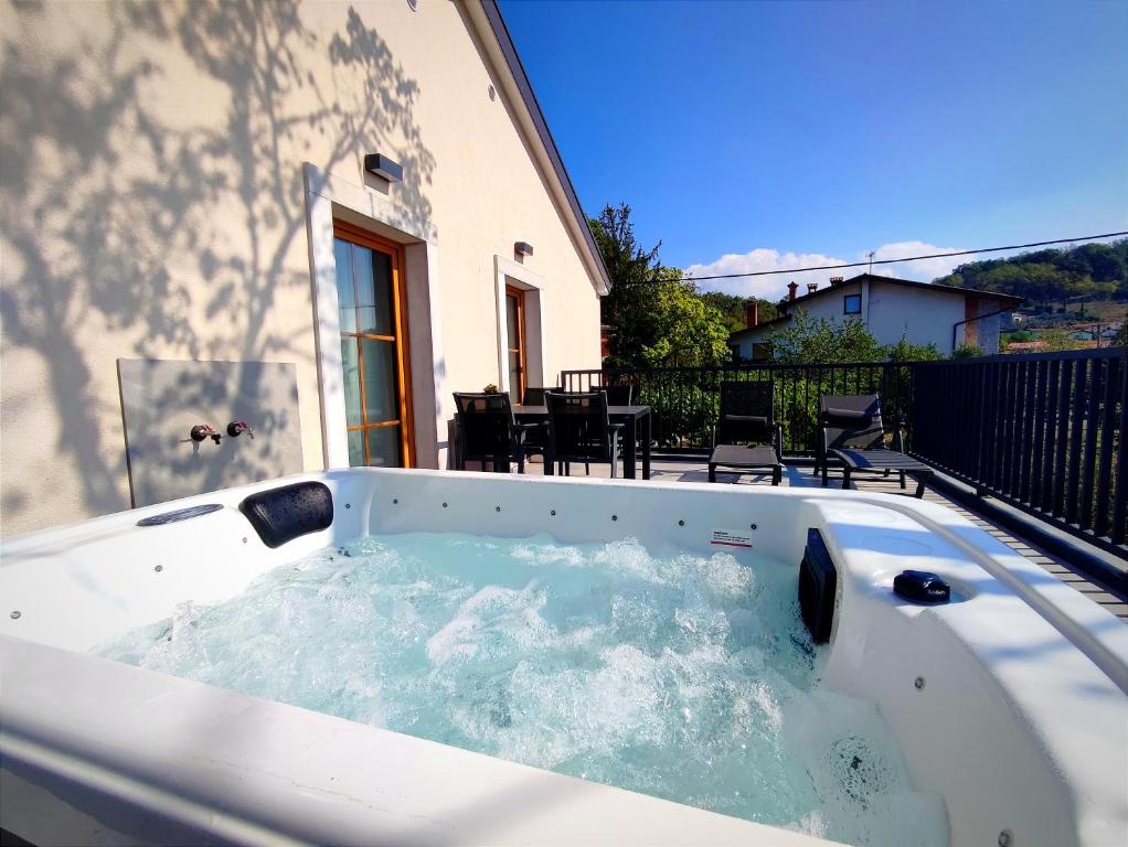 a hot tub on the balcony of a house at Boutique rooms by Petrič winery in Dobravlje