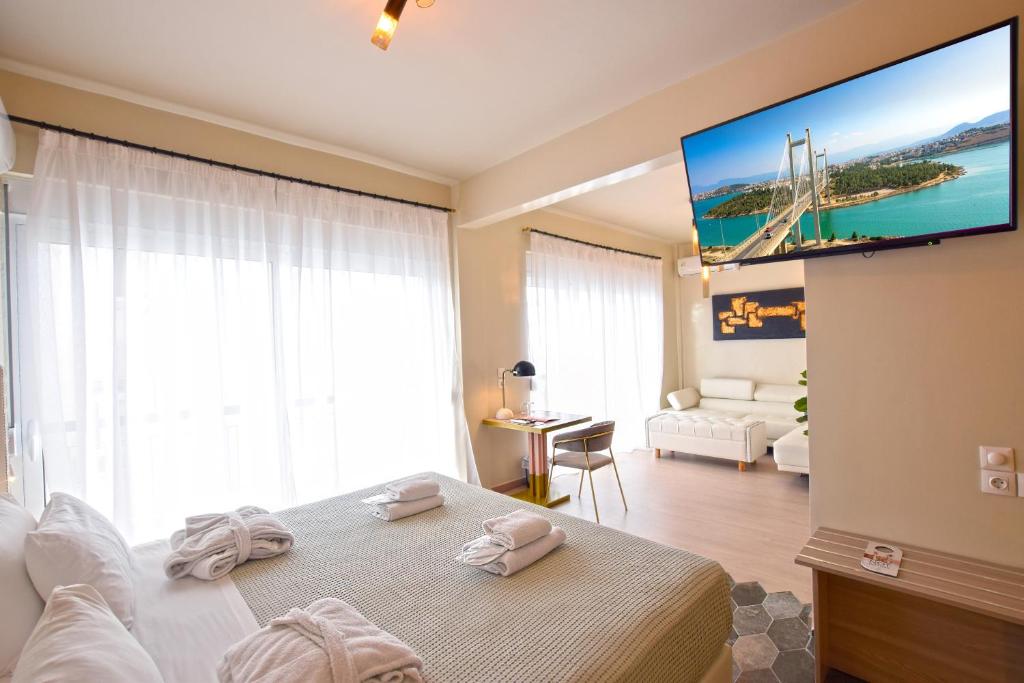 een slaapkamer met een bed en een flatscreen-tv bij John's Hotel in Chalkida