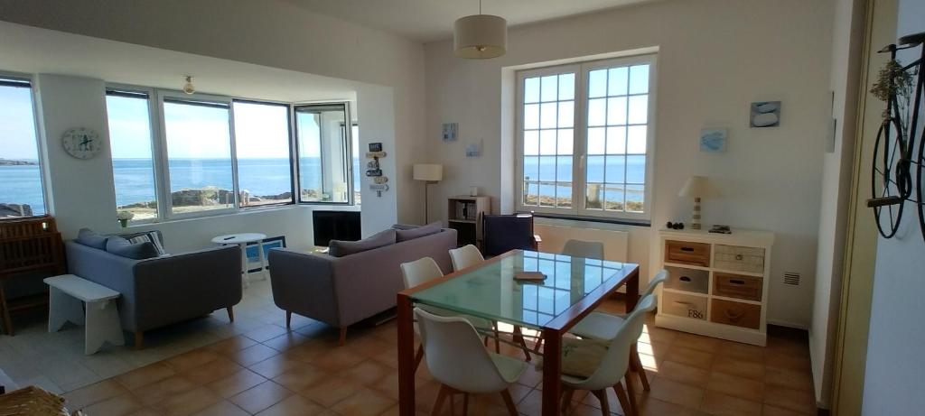 a living room with a table and chairs at Vue imprenable sur la mer à Batz sur Mer in Batz-sur-Mer