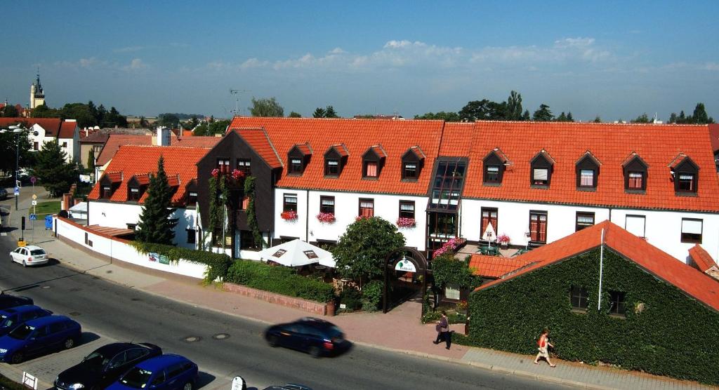 a building with an orange roof on a city street at Park Hotel Pruhonice in Pruhonice