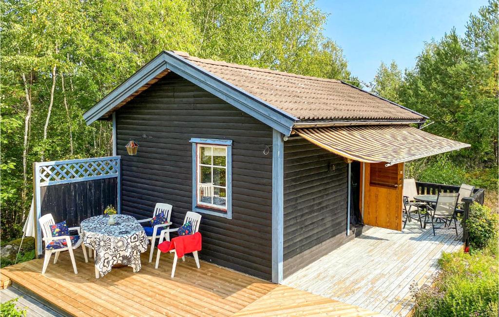 a tiny house with a table and chairs on a deck at Amazing Home In Gamleby With Wifi And 1 Bedrooms in Gamleby