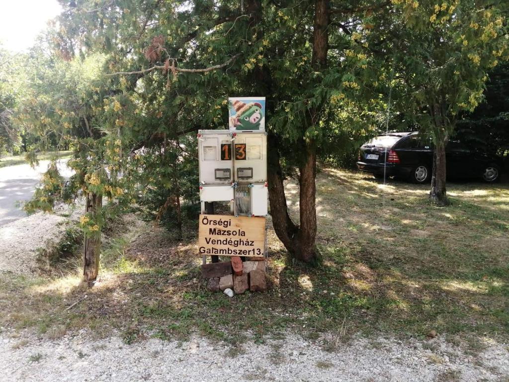 ein Schild, das neben einem Baum sitzt in der Unterkunft Őrségi Mazsola Vendégház in Őriszentpéter