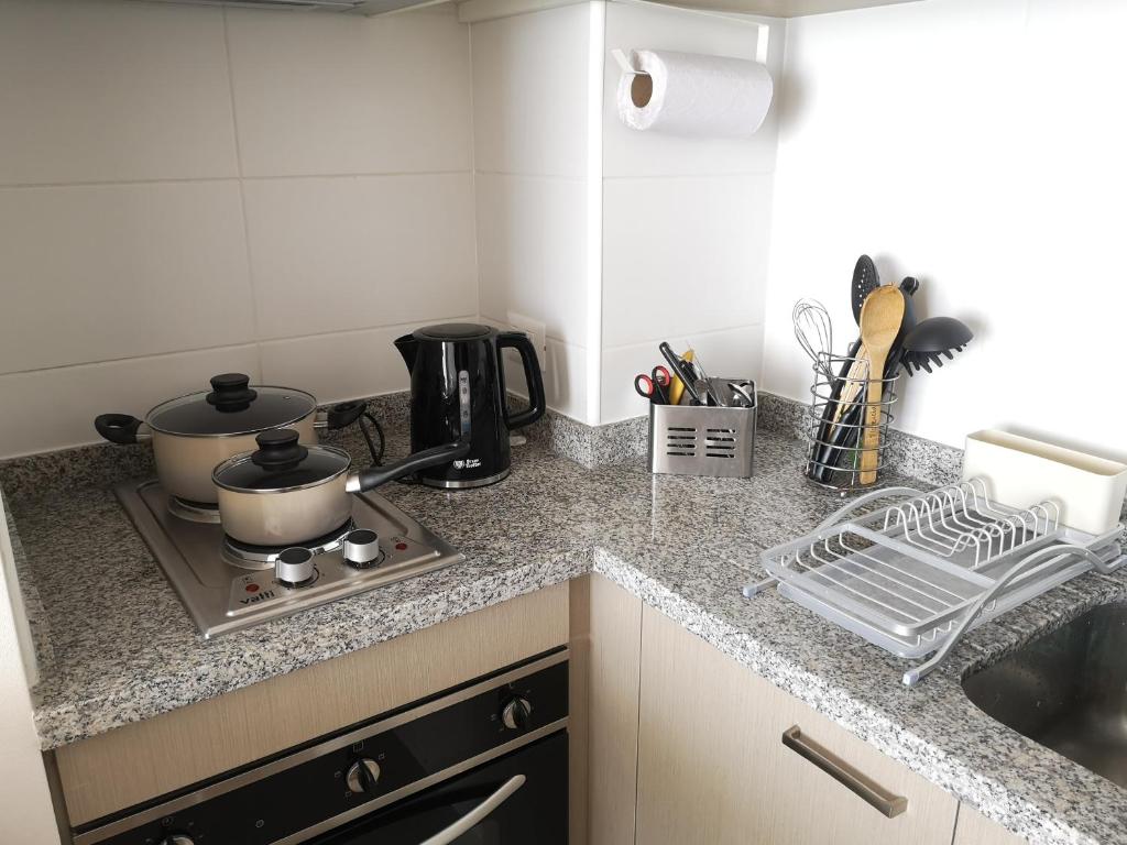 a kitchen counter with a stove with a pot on it at Tranquilo y Acogedor departamento en Con Con in Concón