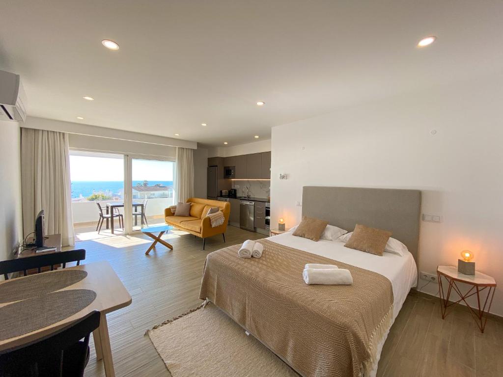 una camera da letto con un letto grande e un soggiorno di Estúdio com Fantástica Vista Mar - Praia da Luz a Luz