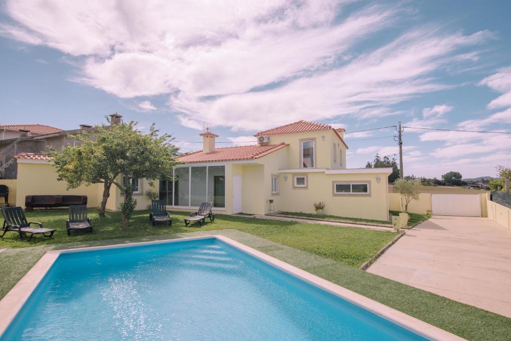 Outeiro Maior的住宿－Casa Dona Ermelinda - Silêncio - Conforto - Natureza，一座带游泳池和房子的别墅