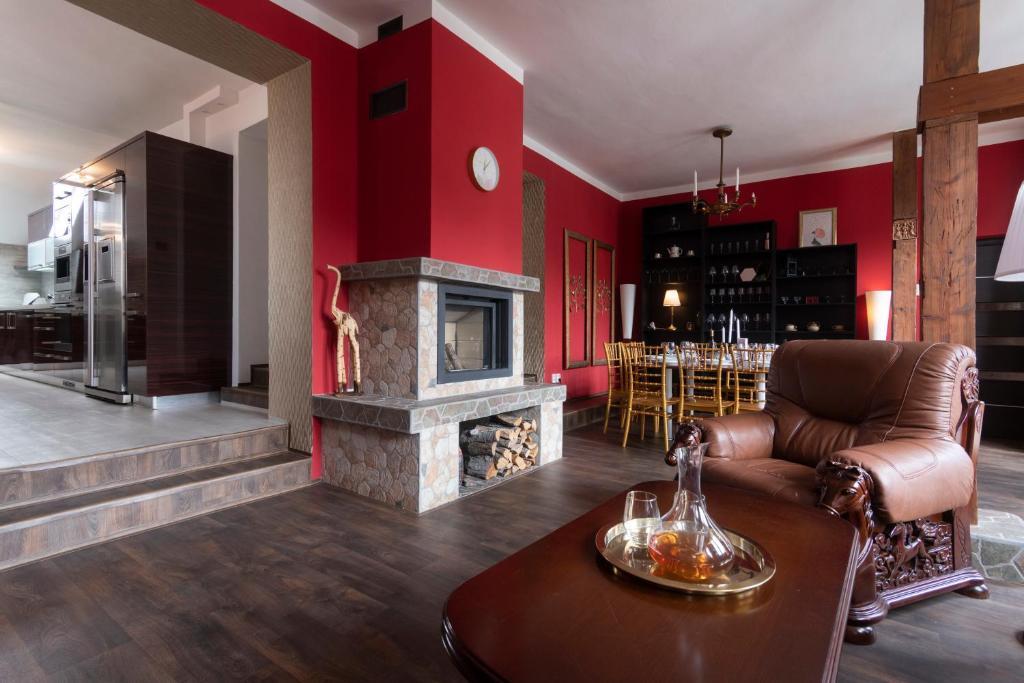 a living room with red walls and a fireplace at Golden Tree Loft in the Heart of Prague in Prague