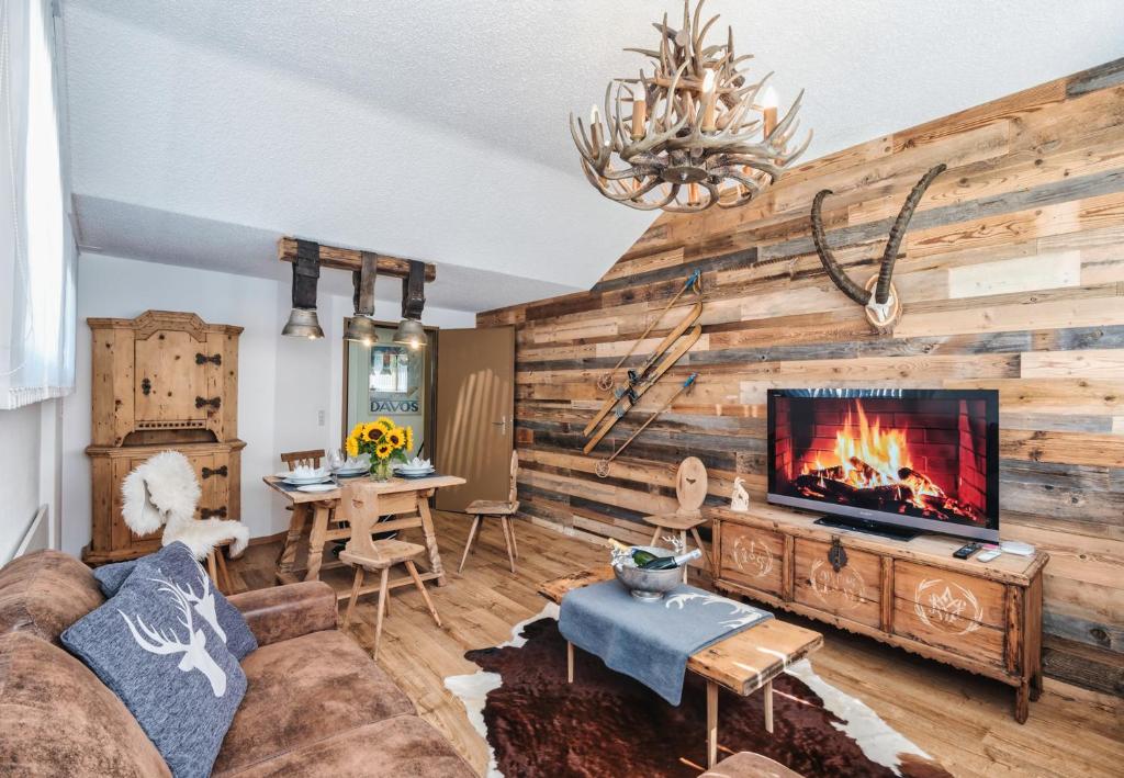 a living room with a couch and a fireplace at Casa Capricorn in Davos