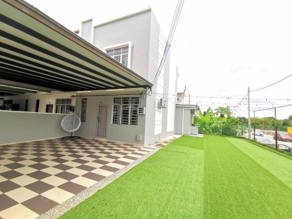 a house with a green lawn in the yard at ₘₐcₒ ₕₒₘₑ Premium Suite 3R2B CorNer @Mount Austin 【TMN DAYA】 in Johor Bahru